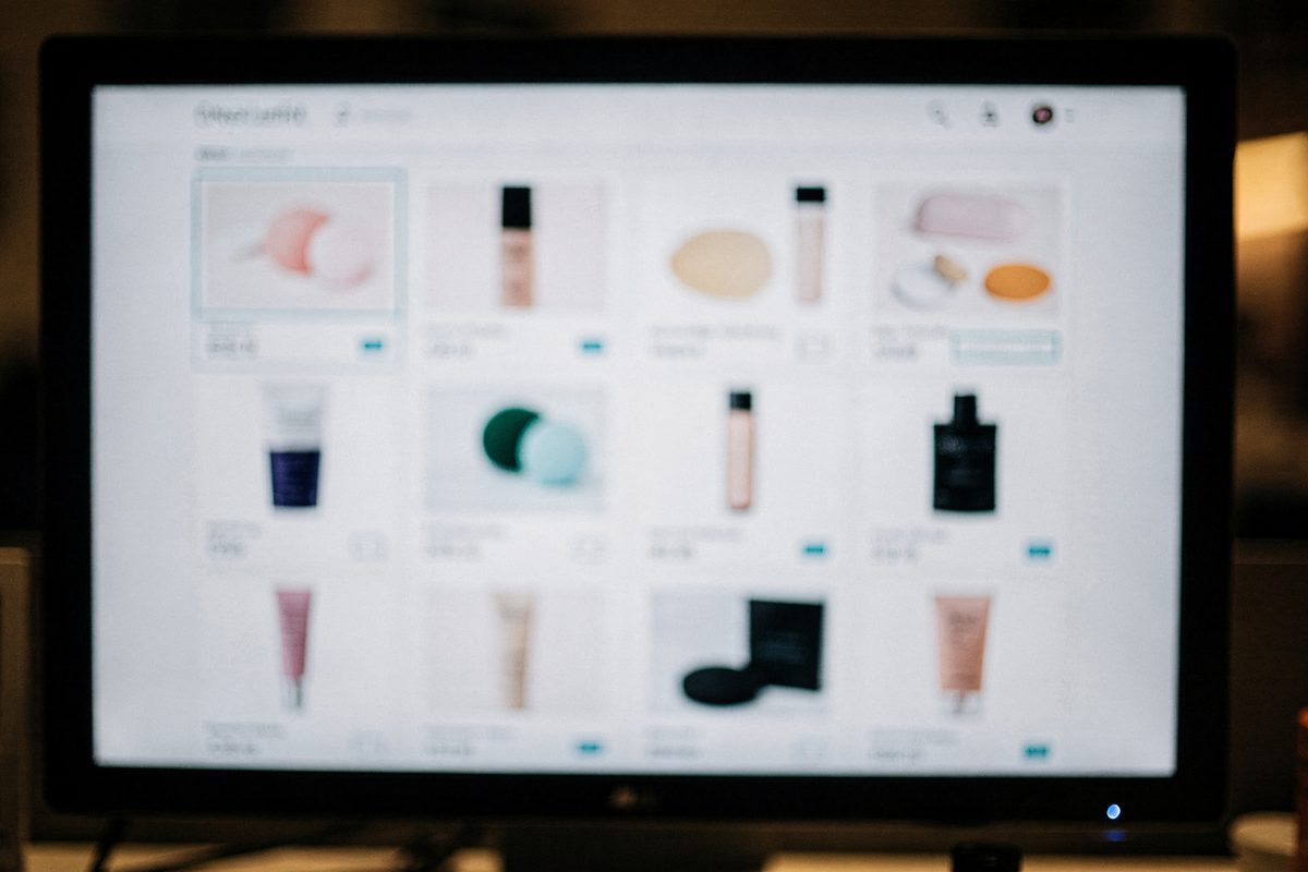 A monitor showing a soft-focus item marketplace grid interface with cyan highlight states